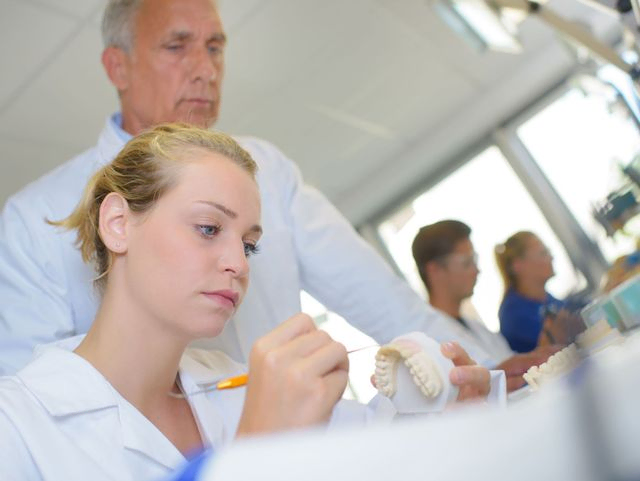 dentistas trabajando con prótesis